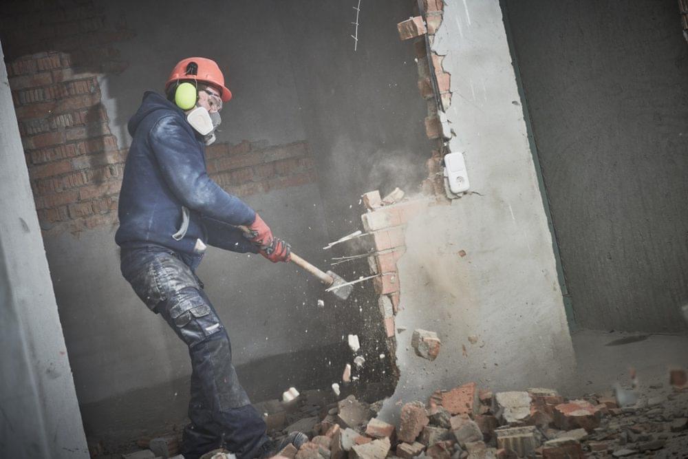 #1 Interior Demolition 1 Demolition,Work,And,Rearrangement.,Worker,With,Sledgehammer,Destroying,Wall
